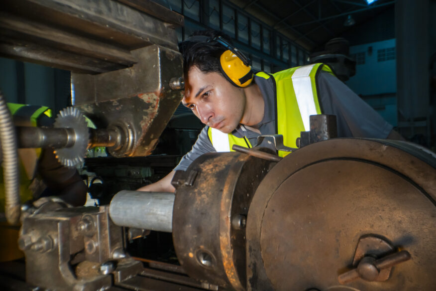 man with heavy machinery and ear protection depicting workers compensation for industrial deafness