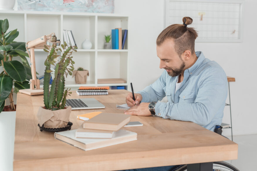 Image is of a man in a wheelchair writing, to depict Learn what an executor of a will does in Australia