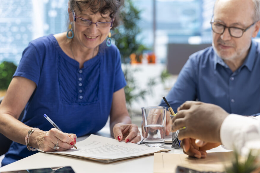 Mature woman signing a document, representing her signing a 'power of attorney nsw