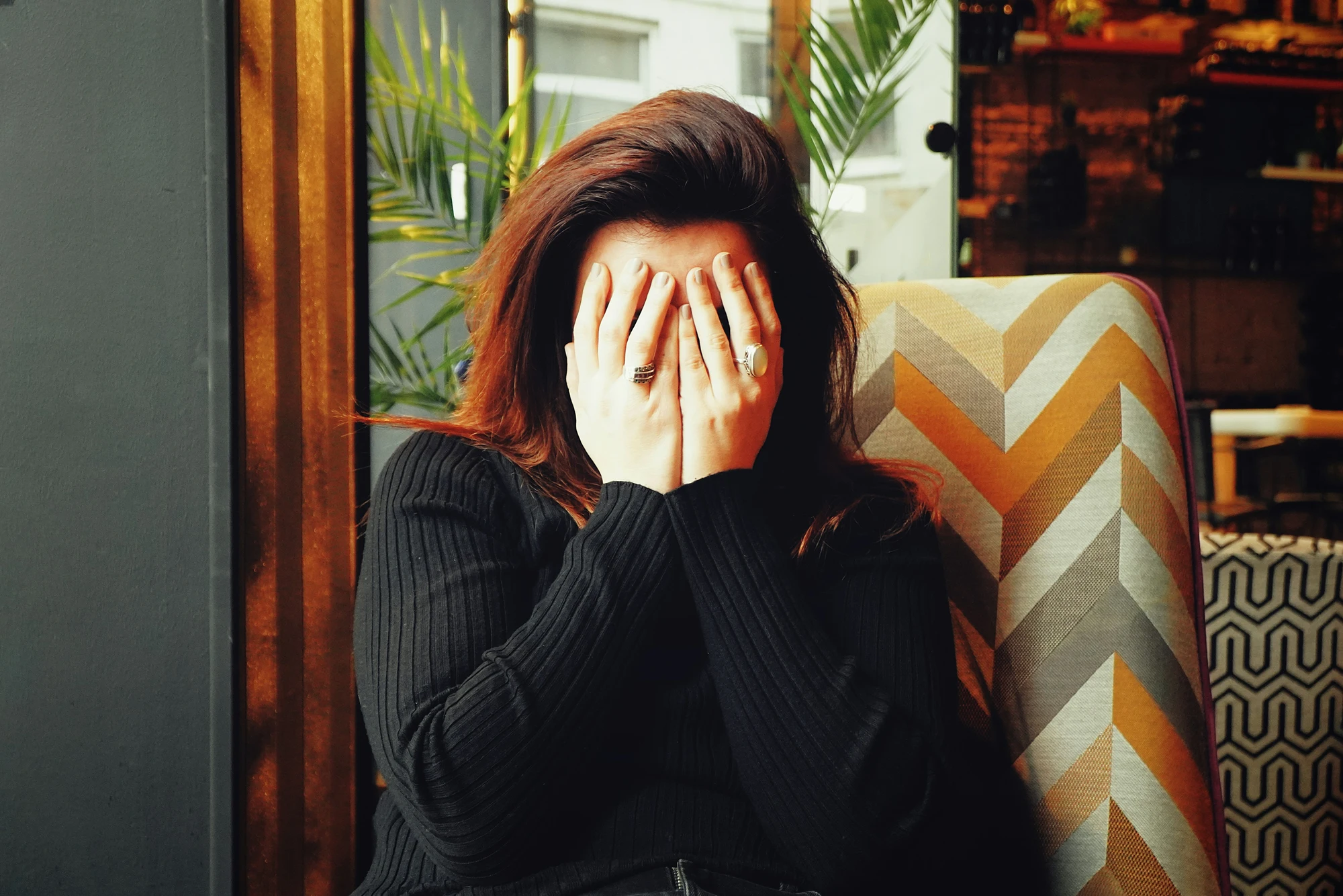 Woman with her face in her hands, looking stressed about a legal dispute
